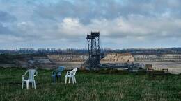 In Garzweiler werden jährlich bis zu 25 Millionen Tonnen Braunkohle gefördert. Damit ist Garzweiler der zweitgrößte Tagebau Deutschlands und einer der größten in Europa. Direkt an der Kante liegt eine Mahnwache der Braunkohlegegner. 